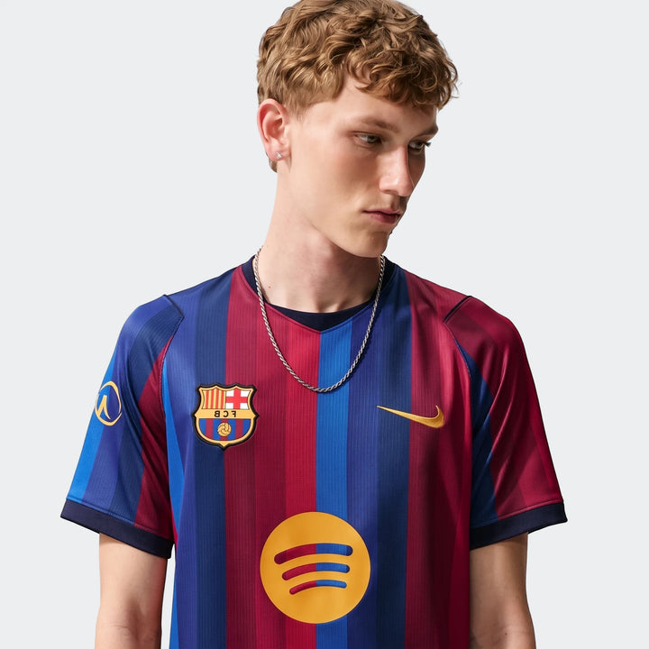 Male model wearing a blue and red striped Fc Barcelona 2026/27 Stadium Home Nike Dri-Fit soccer replica jersey.