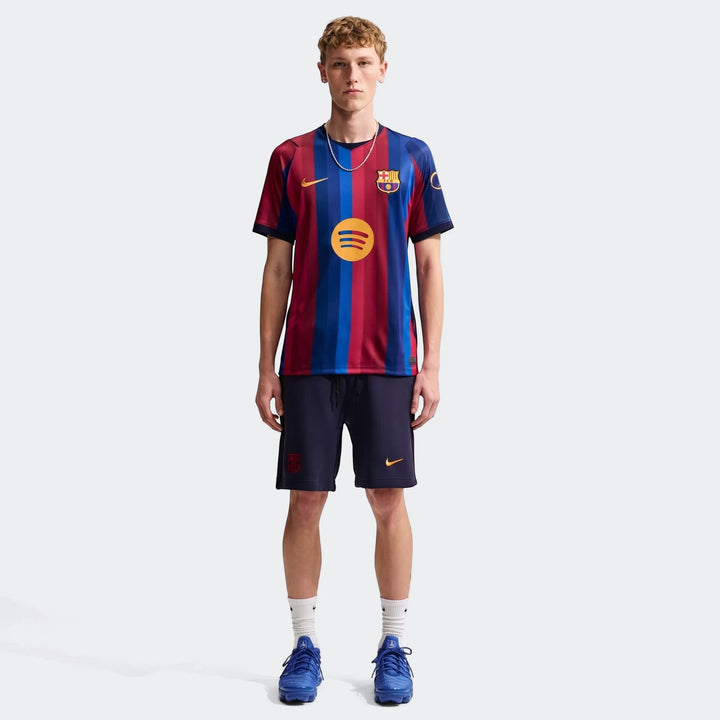 Male model wearing an FC Barcelona 2026/27 Stadium Home Men's Nike Dri-Fit Soccer Replica Jersey and navy blue shorts.