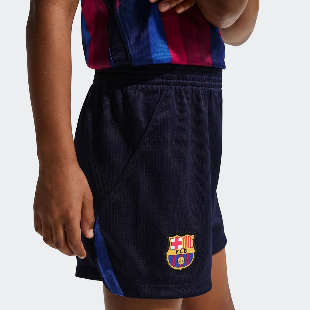 Close-up of Fc Barcelona 2026 Stadium Home little kids' navy blue soccer shorts with the FCB crest on the leg.
