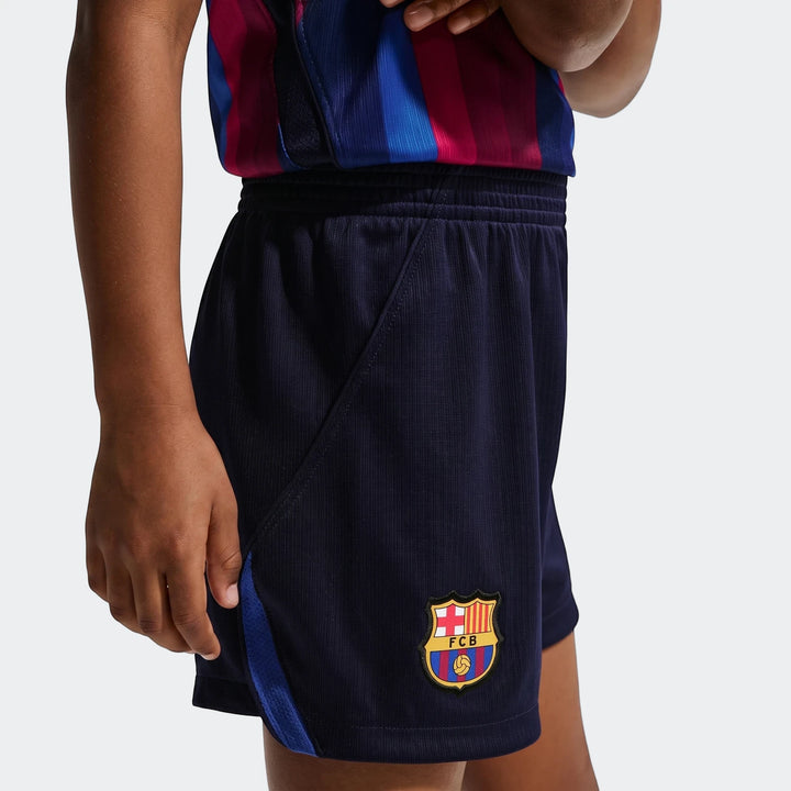 Close-up of Fc Barcelona 2026 Stadium Home little kids' navy blue soccer shorts with the FCB crest on the leg.