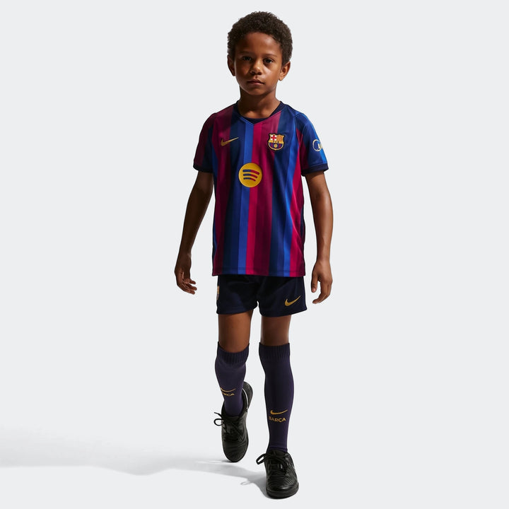 Little boy wearing a Nike FC Barcelona 2026 Stadium Home 3-Piece Soccer Replica Kit with blue and red stripes.