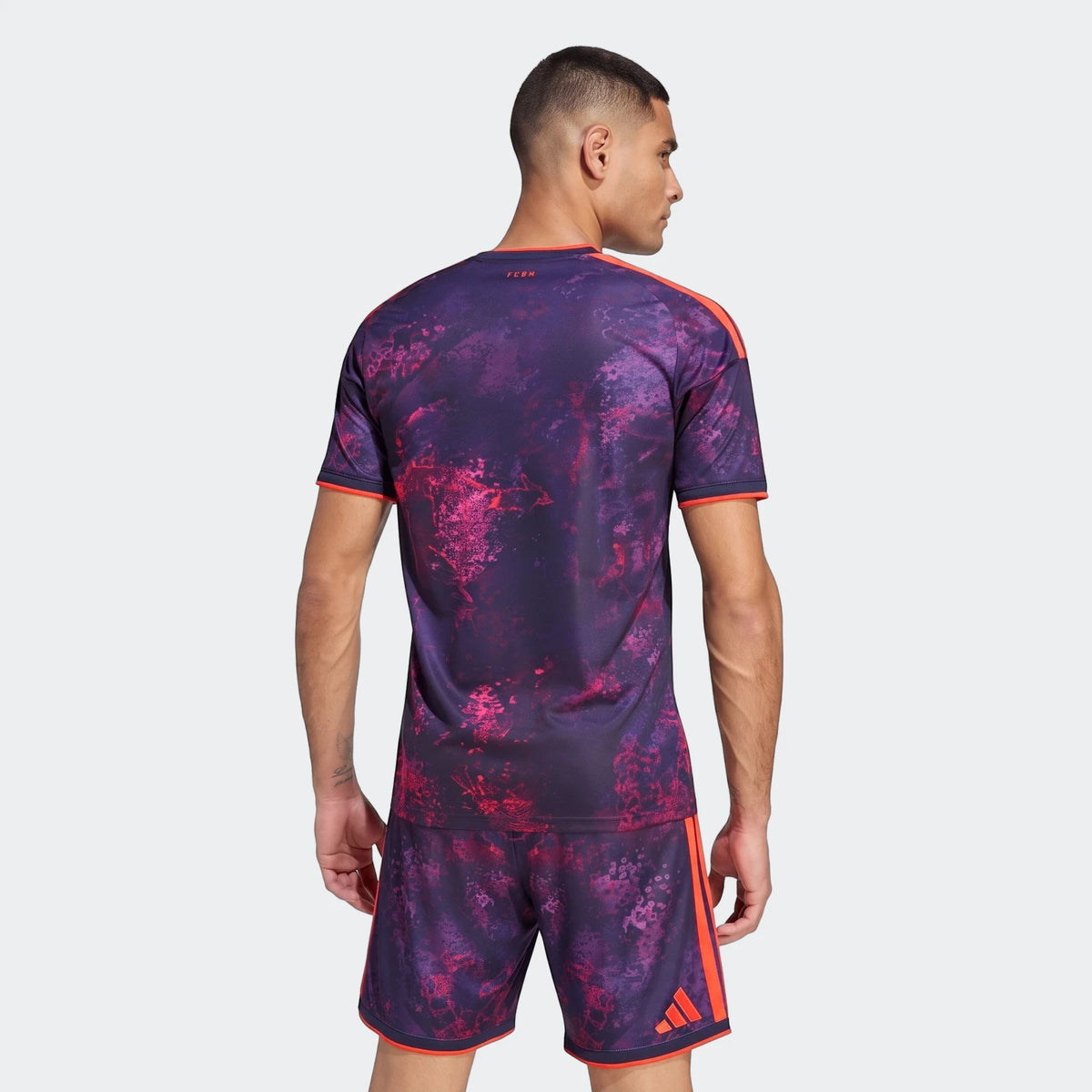 Male model wearing the Fc Bayern 26/27 Third Jersey and matching shorts, featuring a unique purple and red abstract pattern,