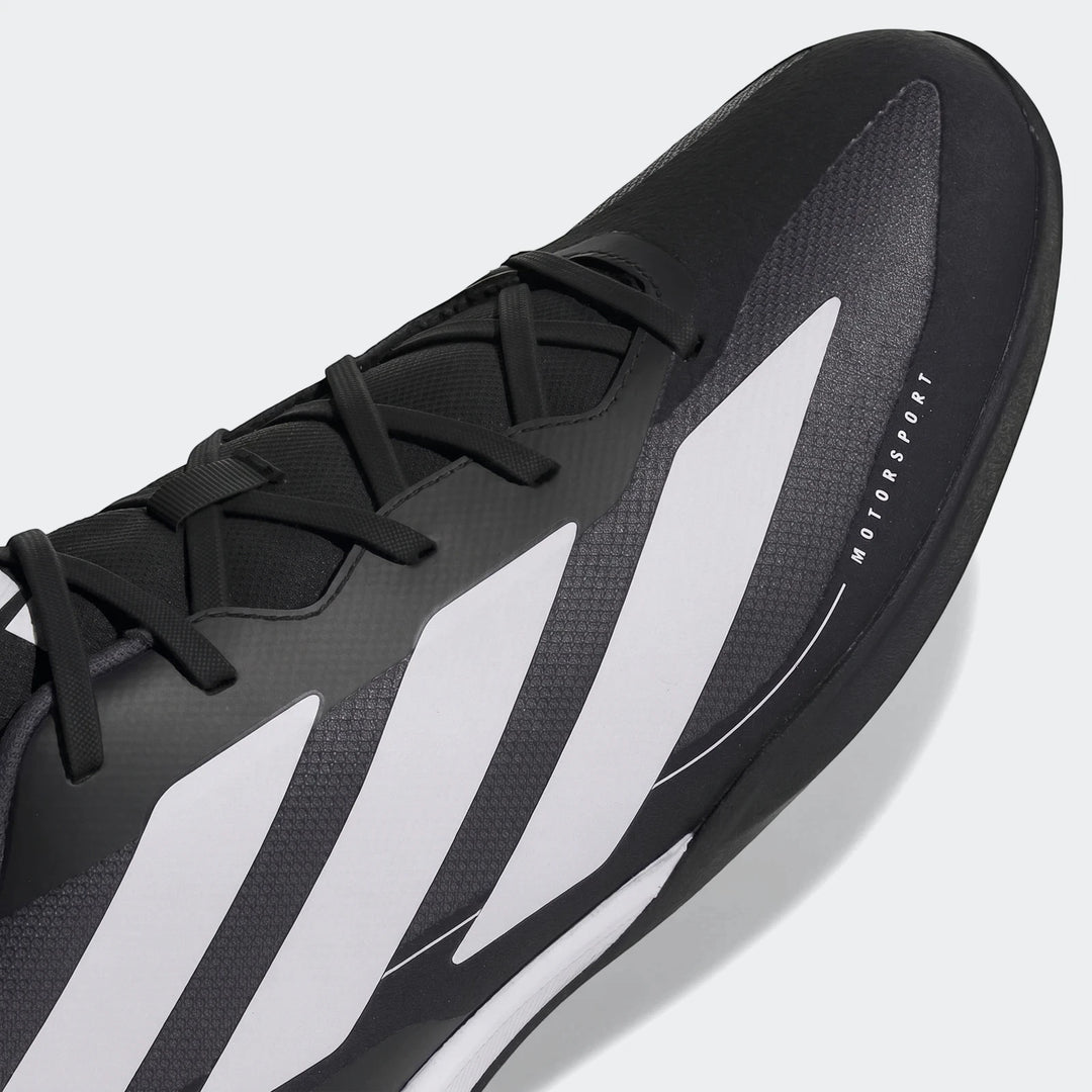 Close-up of a black and white Feroza Base athletic shoe, featuring detailed laces and side stripes with 'MOTORSPORT' text.