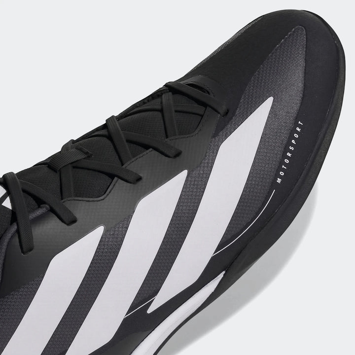 Close-up of a black and white Feroza Base athletic shoe, featuring detailed laces and side stripes with 'MOTORSPORT' text.