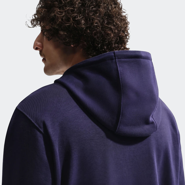 Men's Fff Club Blue Nike Soccer French Terry Pullover Hoodie, back view on a model with curly hair