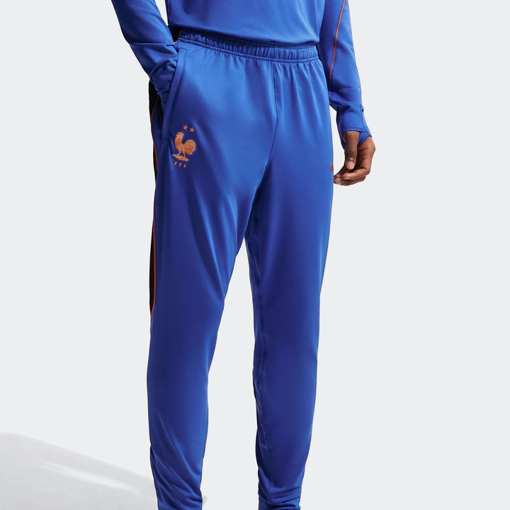 Men's Fff Strike Blue Nike Dri-Fit Soccer Knit Pants, shown worn by a model from mid-torso to thigh, featuring the FFF crest.