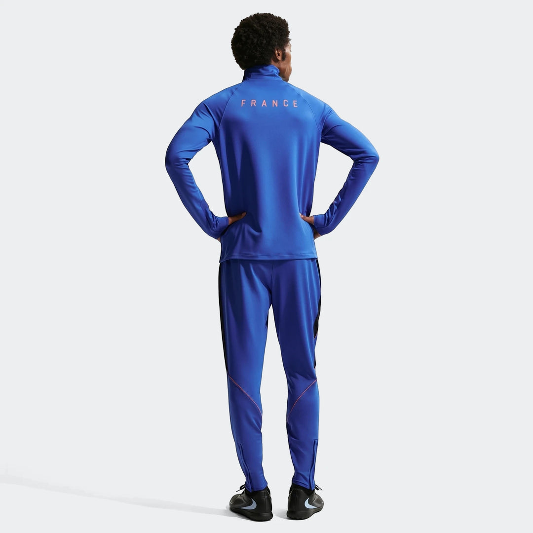 Men's Fff Strike Blue Nike Dri-Fit soccer tracksuit, featuring knit pants and a full-zip jacket, worn by a model from the