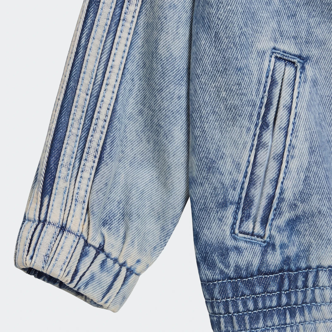 Close-up of a light blue Firebird Denim Track Top sleeve with three white stripes and elasticated cuff, showcasing the denim
