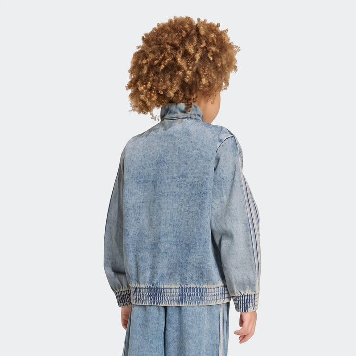 Back view of a person with voluminous curly hair wearing a light wash denim Firebird Loose Track Top and matching bottoms