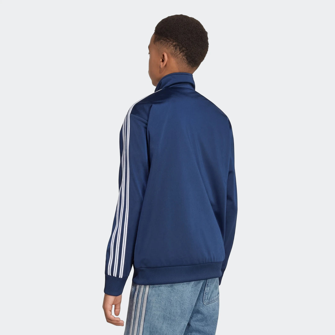 Male model from back wearing navy blue Firebird Loose Reversible Tracktop with white triple stripes on sleeves and light