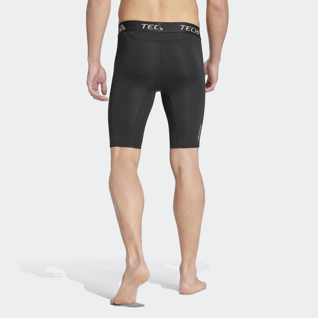 Black football base layer short tights on a male model from the back view, showcasing the fitted design.