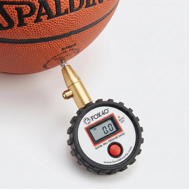 Fox40 Digital Ball Gauge Black Ball Pressure Gauge accurately measuring the air pressure of an orange basketball.