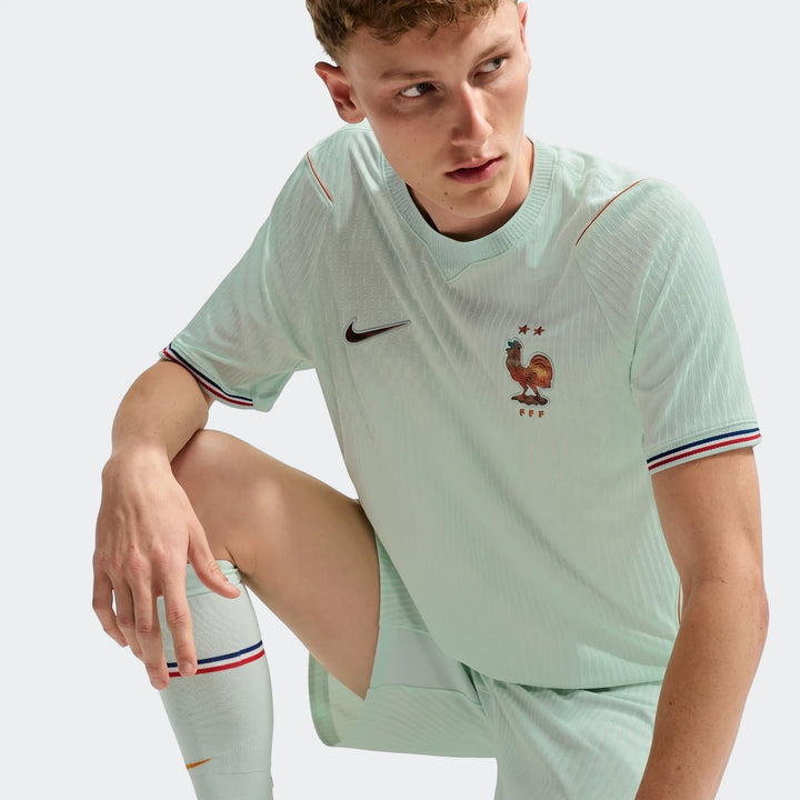 Male model wearing a mint green France National Team 2026 Match Away Nike Aero-Fit soccer jersey with FFF logo.