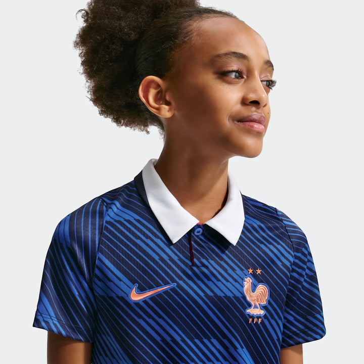 Young girl wearing a blue France National Team 2026 Stadium Home Big Kids' Nike Dri-Fit Soccer Jersey, chest-up view.