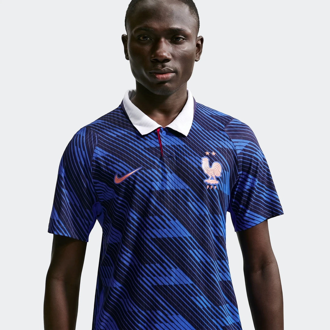 Man wearing a blue striped France National Team 2026 Match Home Nike Aero-Fit Soccer Jersey with a white collar in a studio.
