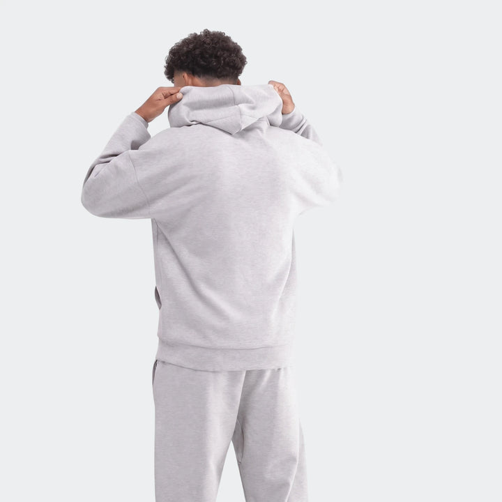 Light grey Future Icons 3-Bar Hoodie and matching sweatpants worn by a model, seen from the back, adjusting the hood.