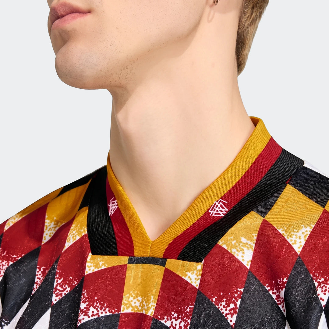 Close-up of a model wearing the Germany 1994 Retro Home Jersey, featuring a vibrant red, black, and yellow geometric pattern.