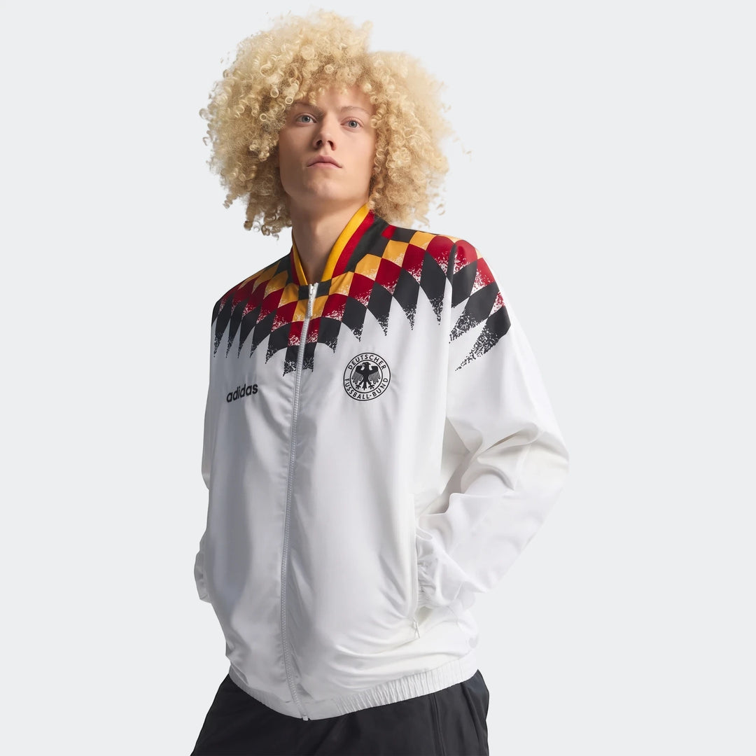 Germany 1994 Retro Track Top in white, featuring iconic black, red, and yellow checkerboard design, worn by a male model.