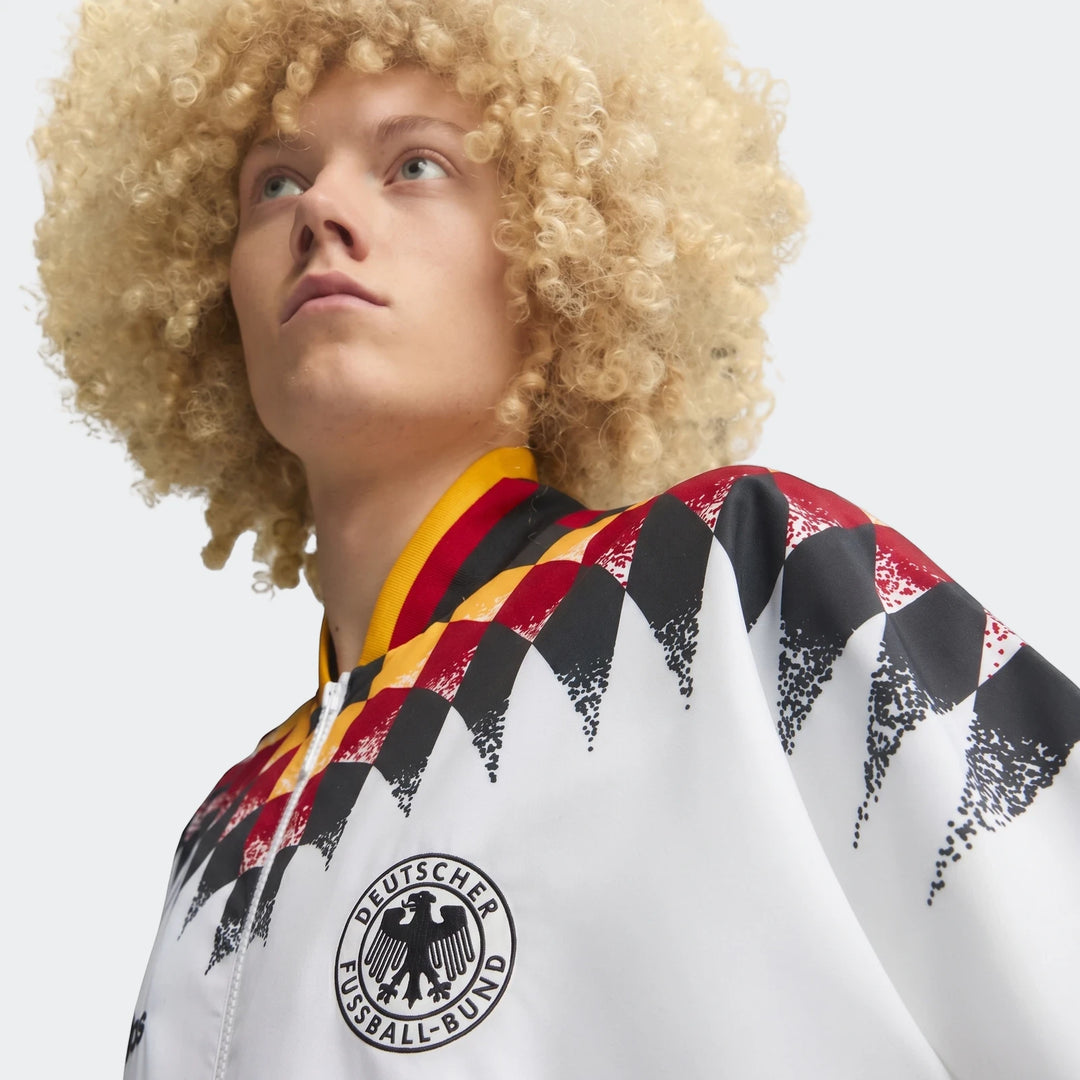 Close-up of a model wearing the white Germany 1994 Retro Track Top, featuring black, red, and yellow diamond pattern on the