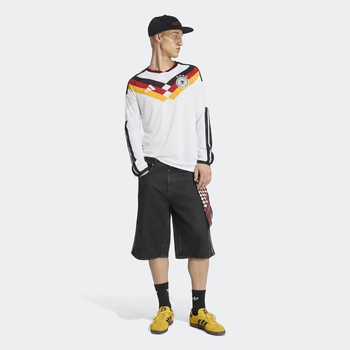 Germany 25/26 Long Sleeve Home Jersey in white with black, red, and yellow accents, worn by a male model with black shorts