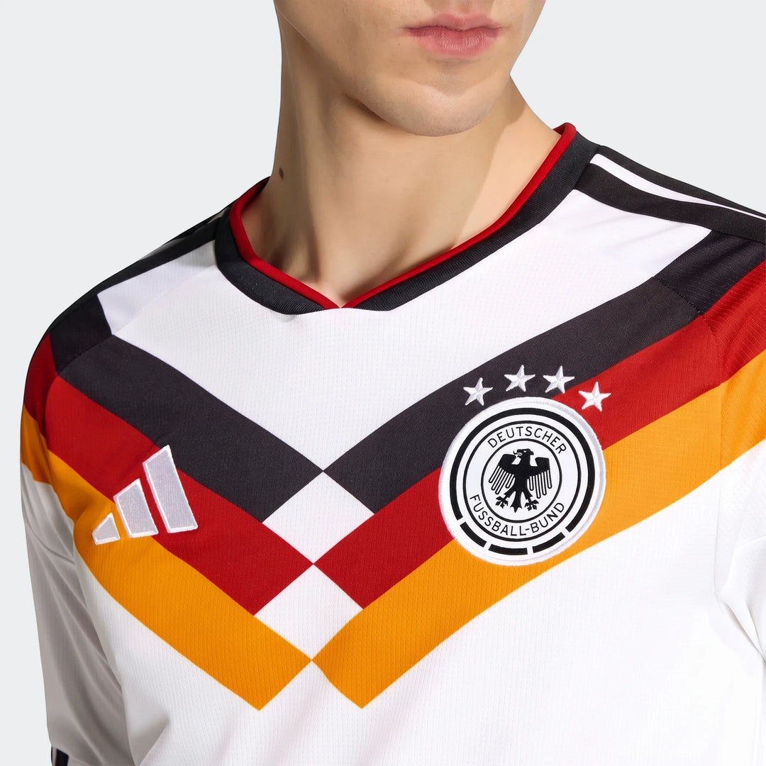 Close-up of a man wearing the white Germany 25/26 Long Sleeve Home Jersey with black, red, and yellow stripes, Adidas and