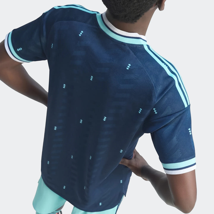 Back view of the Germany 26 Away Authentic Jersey in dark blue with light blue stripes and pattern, worn by a model.
