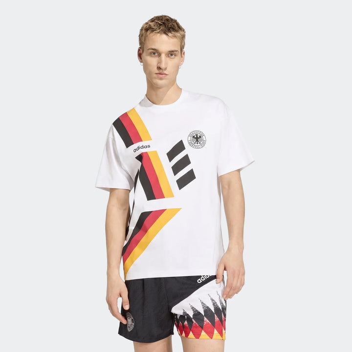 Male model wearing a white Germany T-shirt 1994 with black, red, and yellow stripes, paired with matching black shorts.