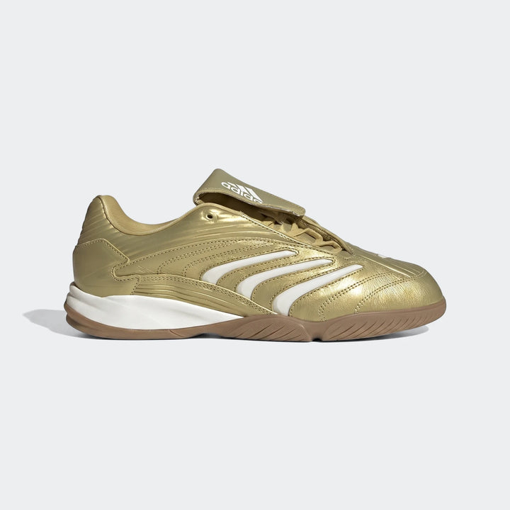 Gold Adidas indoor soccer shoe with white stripes and a gum sole, viewed from the side on a plain background.