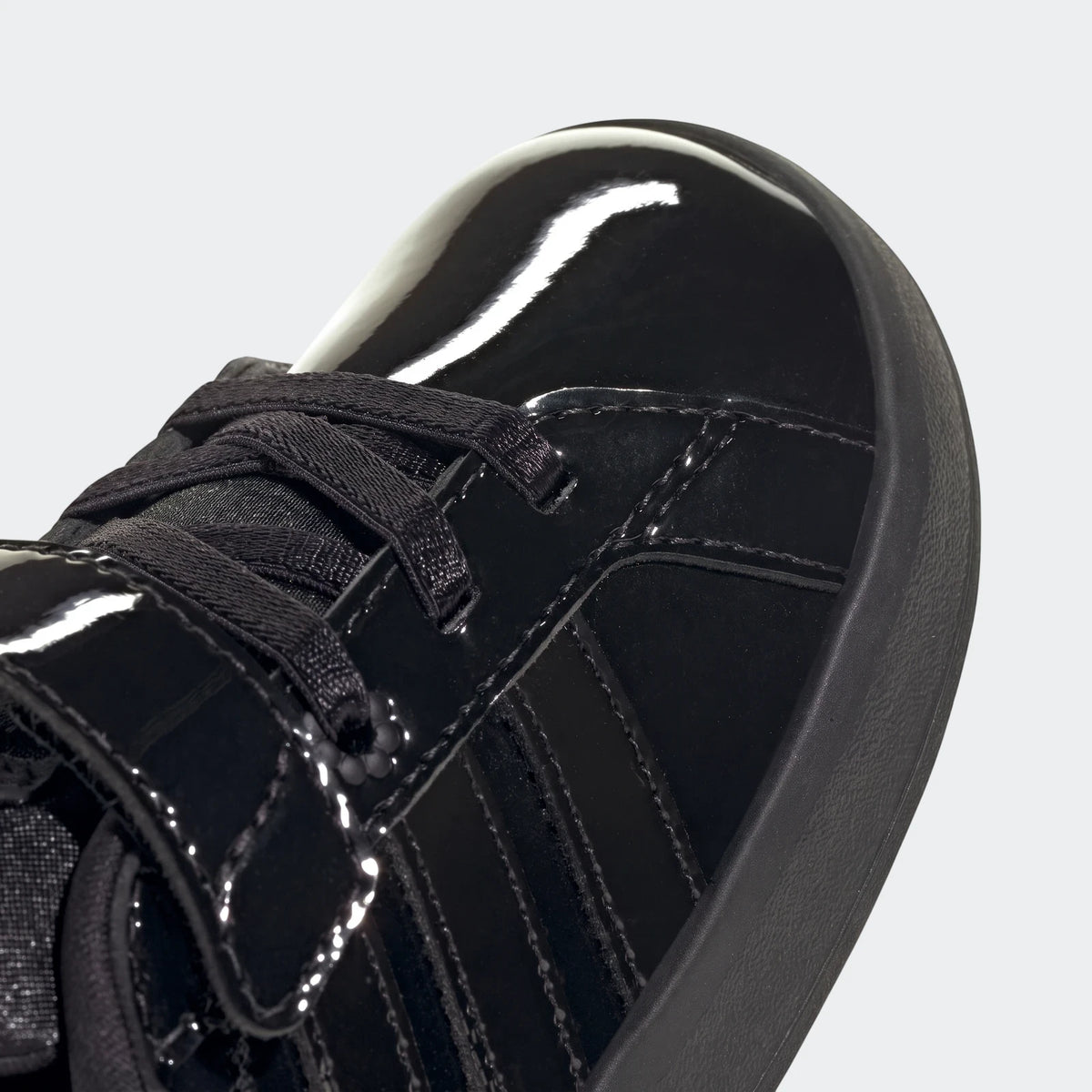 Close-up of a black patent leather Grand Court 3.0 Girls Infant shoe, featuring black laces and iconic side stripes.