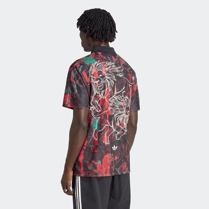Male model from behind wearing a black, red, and green Graphic Football Jersey with a lion graphic and black Adidas shorts.