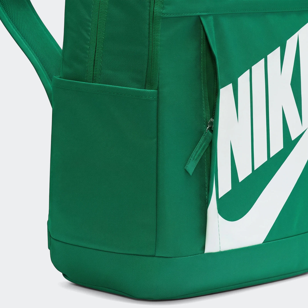 Close-up of a green Nike Elemental backpack showing a side pocket, main compartment zipper, and part of the white Nike logo.