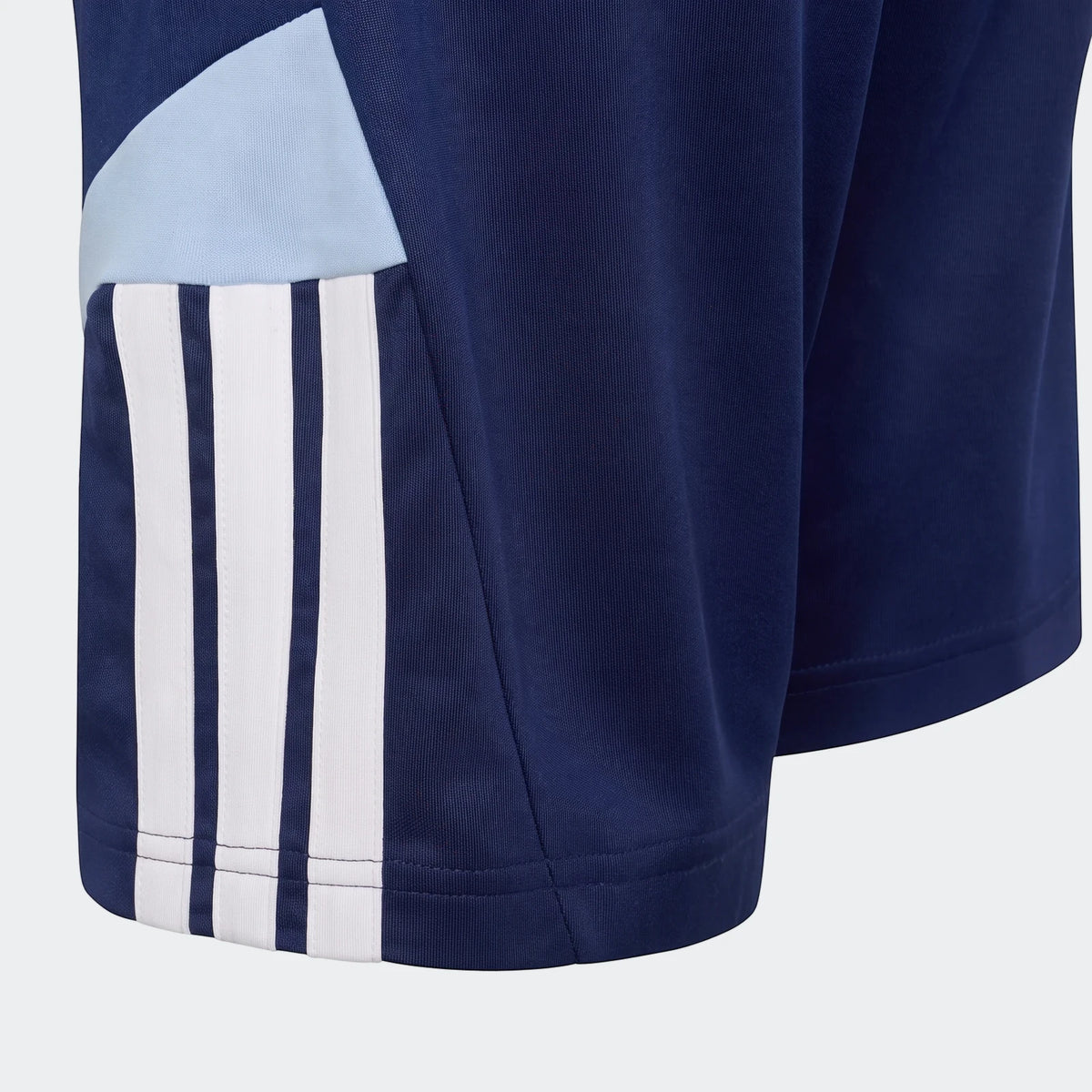 Dark blue House Of Tiro shorts featuring prominent white stripes and a light blue side panel, captured in a close-up.