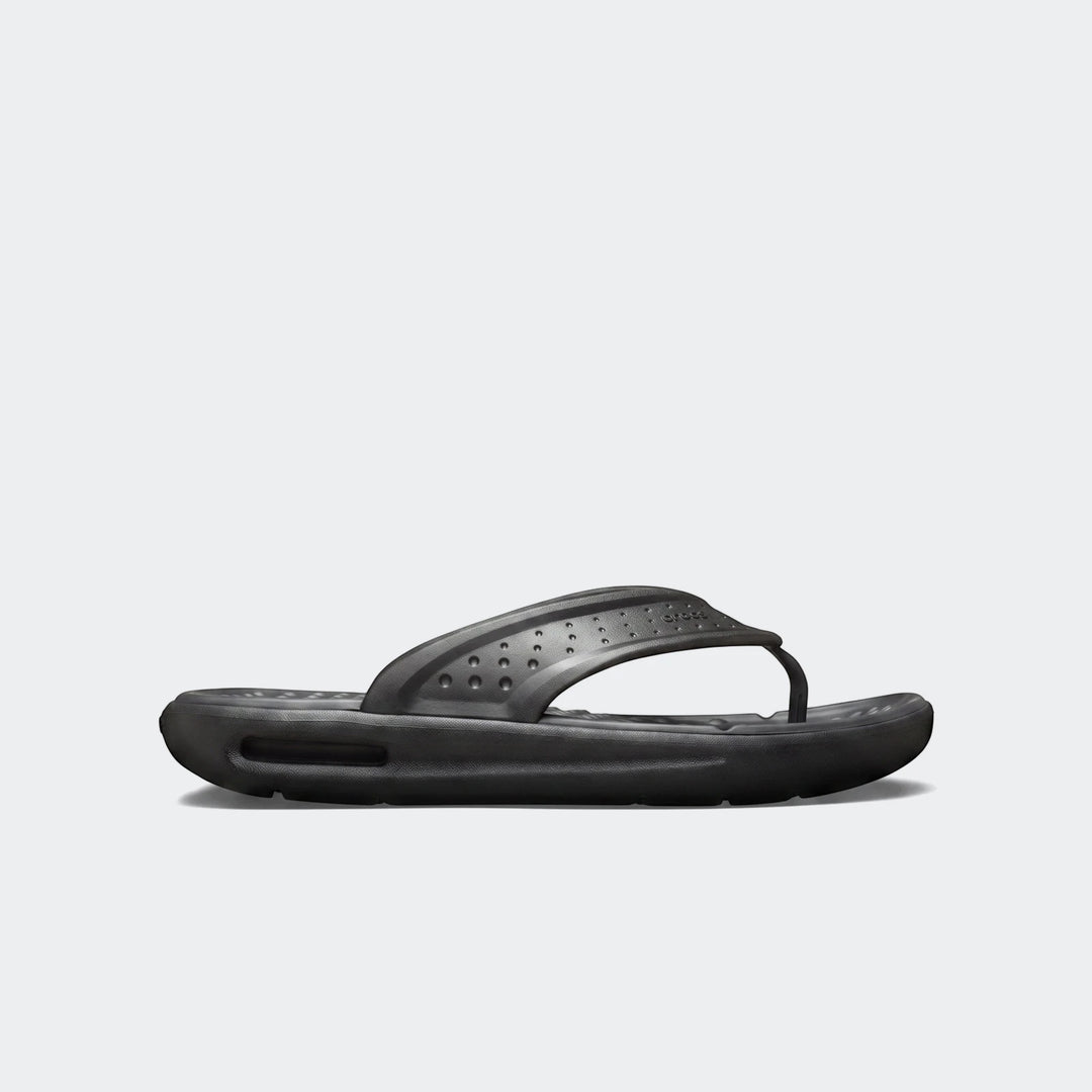 Side view of a black In Motion Lite Ride flip-flop, featuring a perforated strap and thick, cushioned sole.