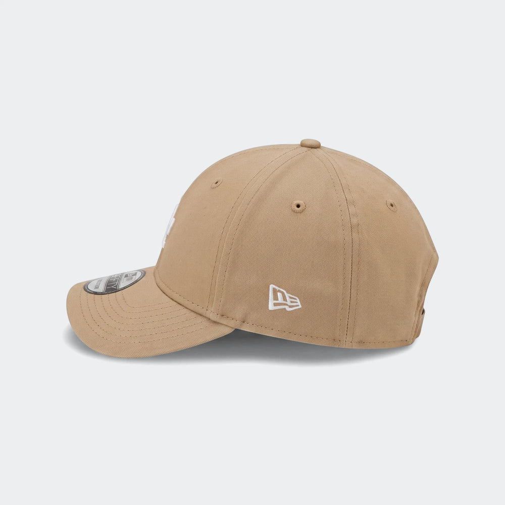 Infant League beige baseball cap shown from a side profile view, featuring its distinct design and logo on the side.