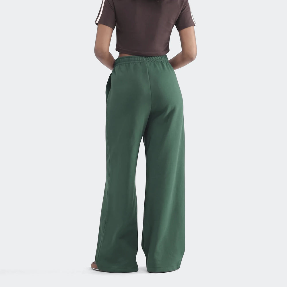 Dark green Infill Heritage Pants, wide-leg design, worn by a model standing with her back to the camera.