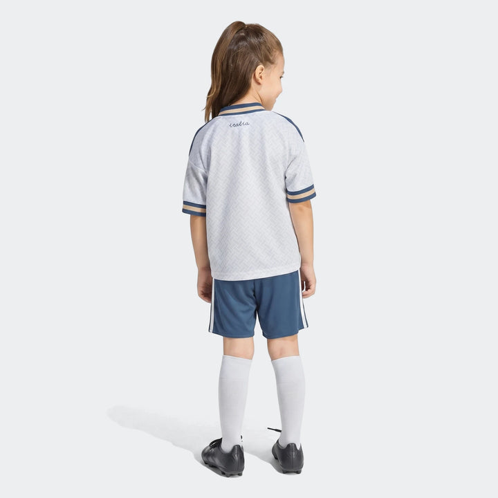 Italy 25/26 Away Mini Kit worn by a child, featuring a white jersey with "italia" text, navy shorts, and white socks, full