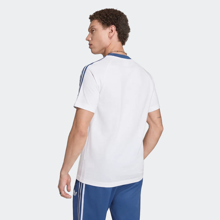 Male model from back wearing white Adidas Italy Originals Graphic T-shirt with blue stripes and blue Adidas shorts with
