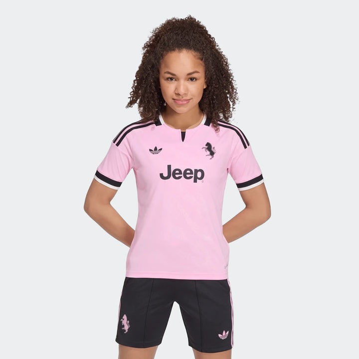 Youth wearing pink and black Adidas Juventus 26/27 Away Jersey and matching shorts, presented in a front view.