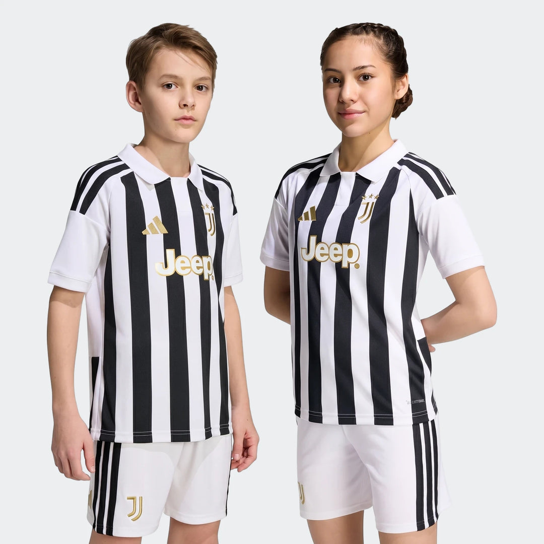 Two kids wear the Juventus 26/27 Home Jersey and shorts. The black and white striped soccer kit features gold logos,
