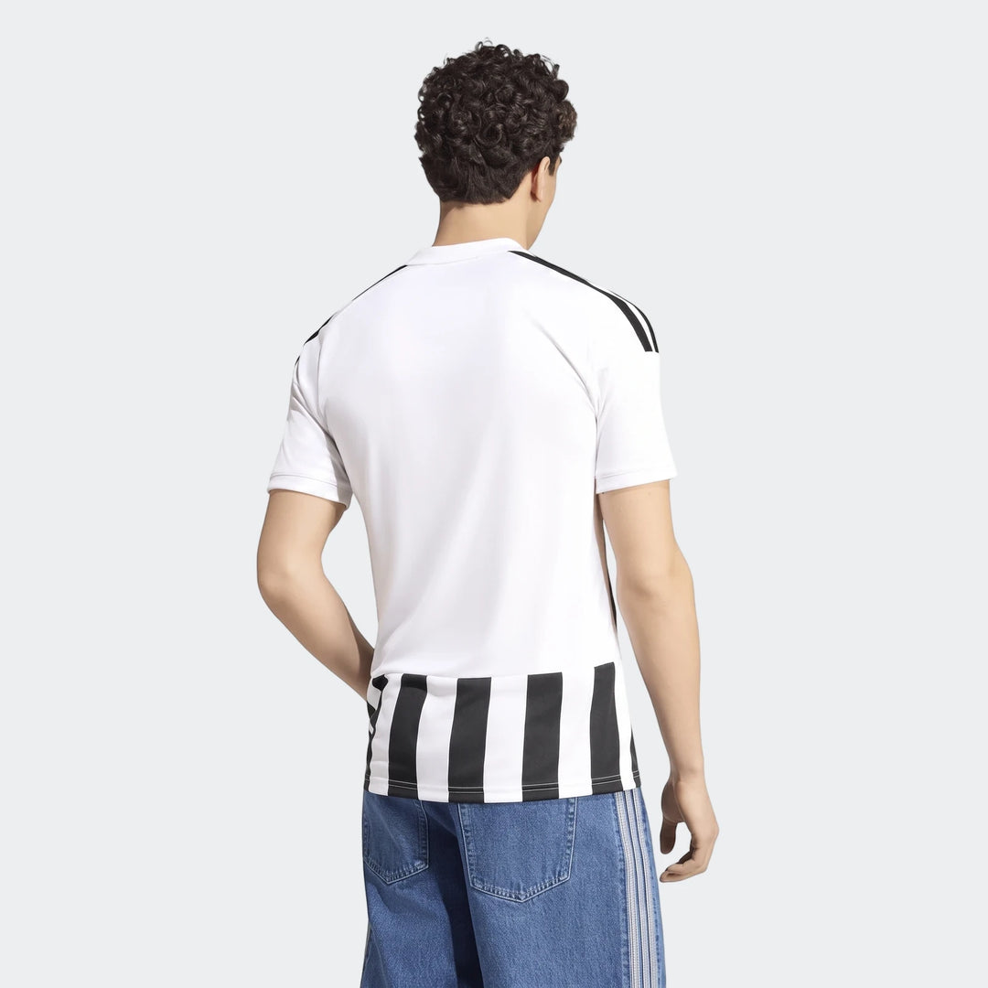 Back view of a male model wearing the Juventus 26/27 Home Jersey, a white and black striped short-sleeve shirt, paired with