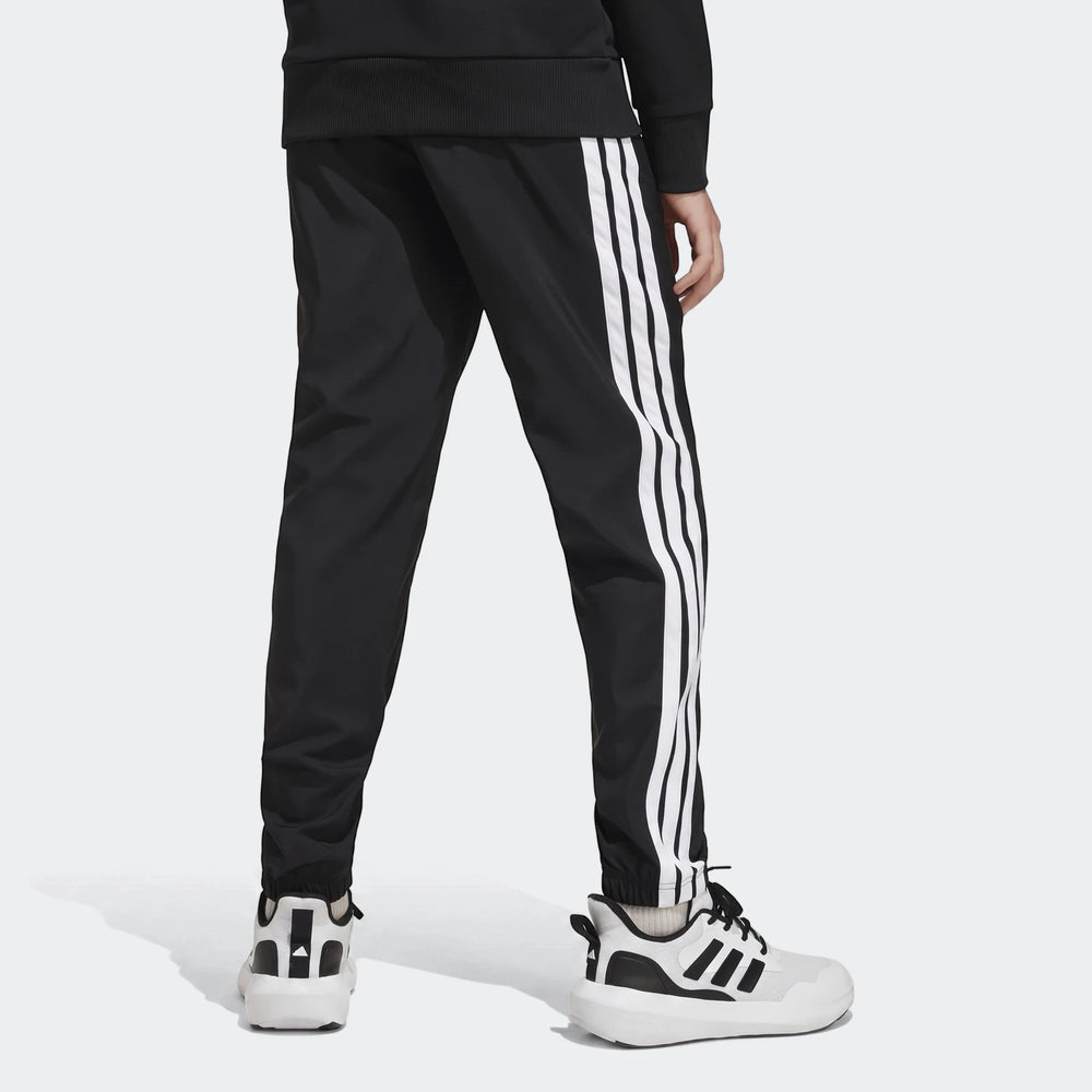 Kids' black Adidas Essentials Climacool tracksuit bottoms with iconic white 3-stripes, shown from the back, paired with