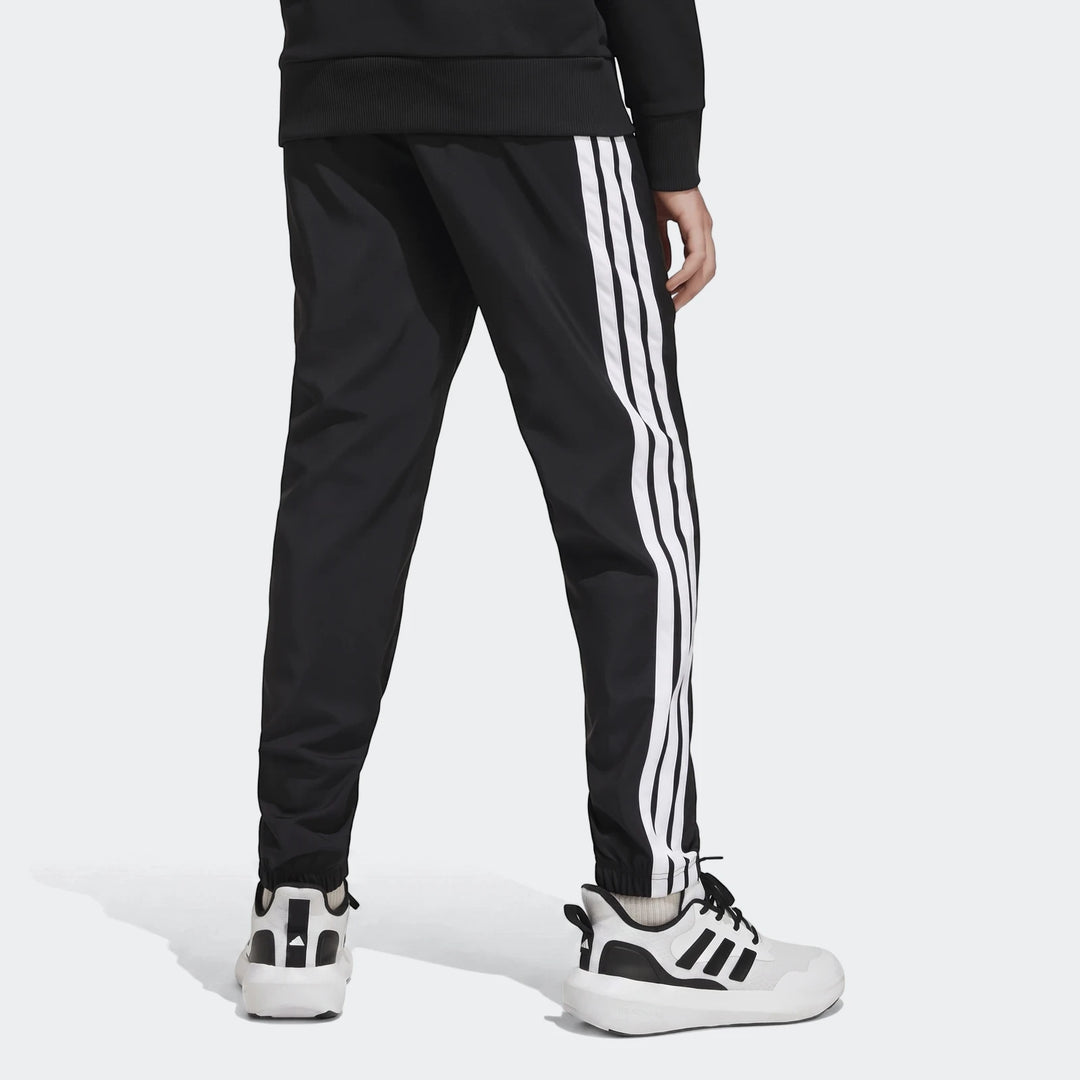 Kids' black Adidas Essentials Climacool tracksuit bottoms with iconic white 3-stripes, shown from the back, paired with