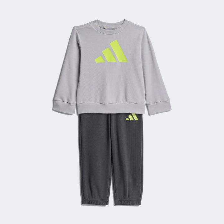 Kids' Adidas Essentials joggers set featuring a light gray sweatshirt with a bold neon yellow logo and dark gray sweatpants,