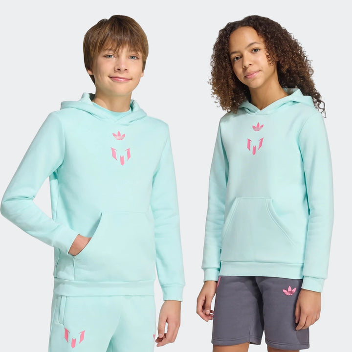 Two kids wear light blue Adidas Messi Youth hoodies. The boy also wears matching track pants, and the girl wears dark gray