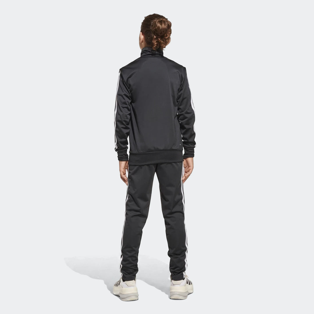 Kids black Adidas Essentials Climacool track suit with white stripes, worn by a young person, shown from the back.