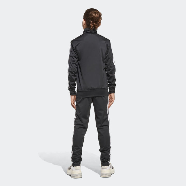 Kids black Adidas Essentials Climacool track suit with white stripes, worn by a young person, shown from the back.