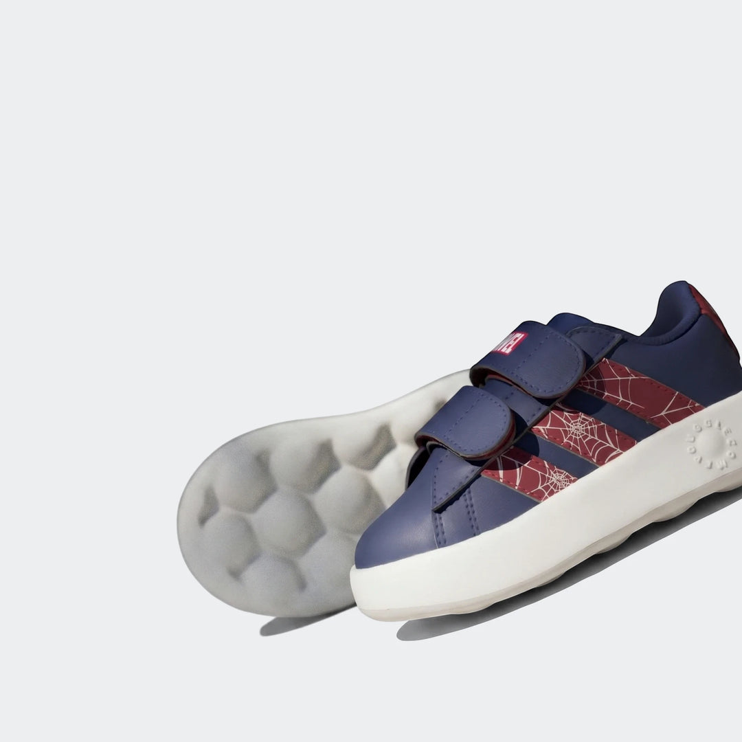Close-up of kids' navy blue Grand Court Spider-Man Cloudfoam Shoes with red web pattern stripes and white soles.