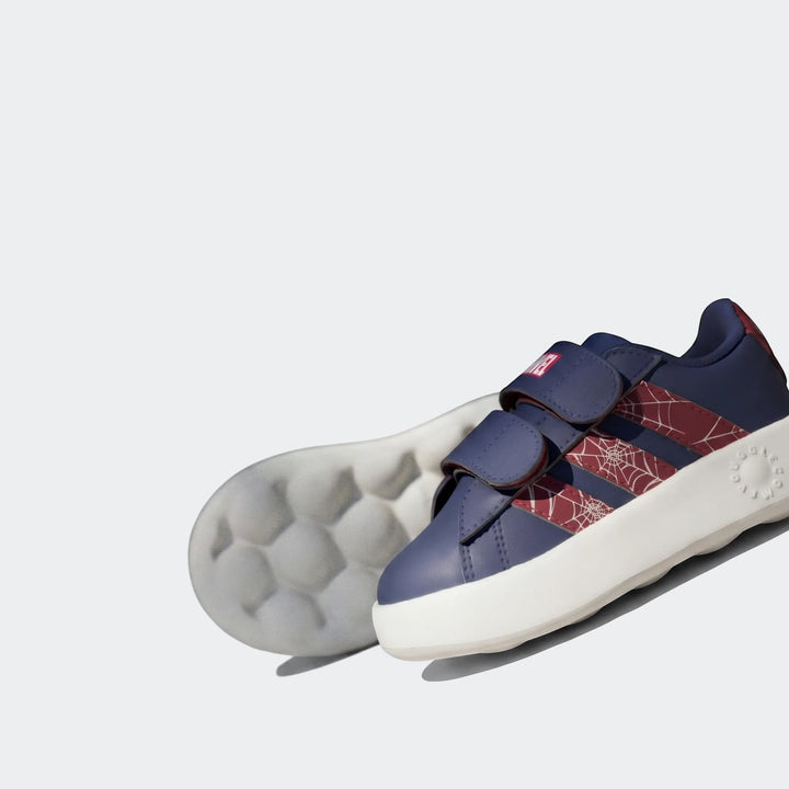 Close-up of kids' navy blue Grand Court Spider-Man Cloudfoam Shoes with red web pattern stripes and white soles.