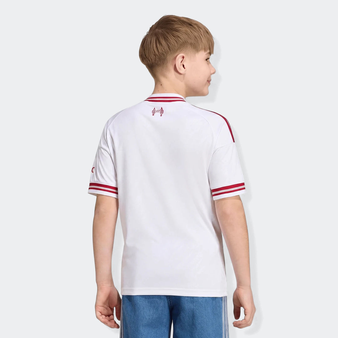 Back view of a young boy wearing a white Kids Liverpool FC 26/27 Away Jersey featuring red trim and a '97' graphic.
