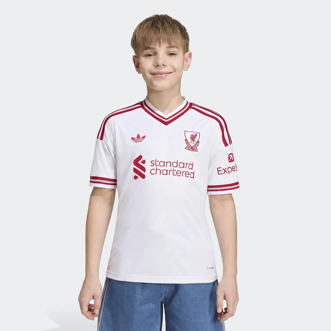 Young boy wearing the Kids Liverpool FC 26/27 Away Jersey, featuring white fabric with red trim, club crest, and sponsor